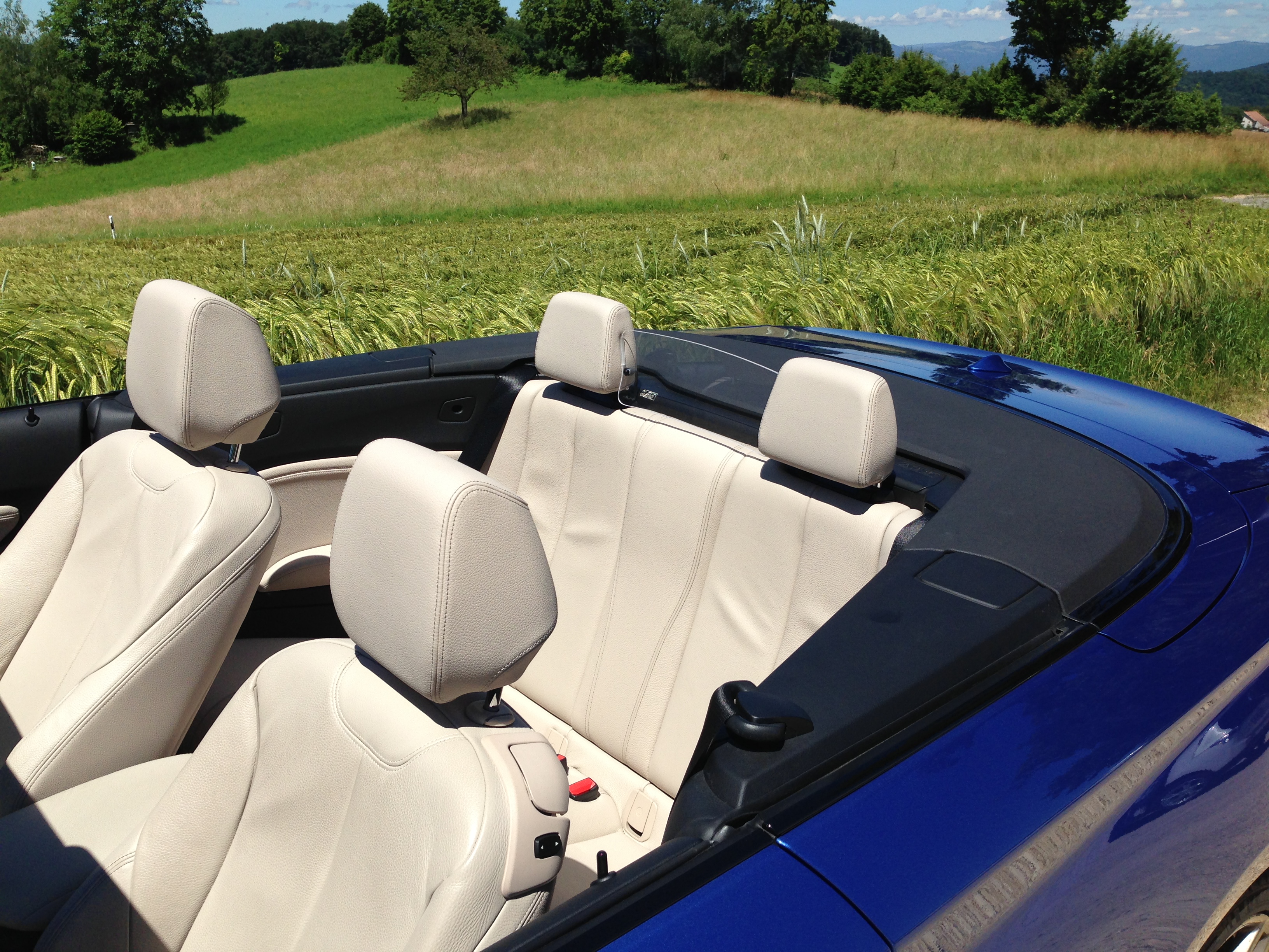 Kinder sitzen geschützt und komfortabel auf der Rückbank eines Cabrios mit AUCO Rücksitz-Windschott